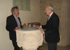 Simon Keyes, Director of the St Ethelburga's Centre shows Michael Henderson the font where Henderson was baptised (Photo: Michael Smith)